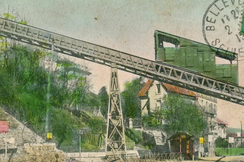Carte postale colorisée : la poutre métallique inclinée du funiculaire de Bellevue monte le coteau au-dessus des voies ferrées.